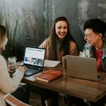 Professional people sitting in front of table laughing together