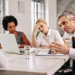 Angry businessman discussing with colleague