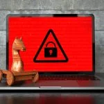 Encrypted notebook with a wooden trojan horse on the table