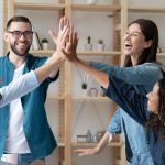 l employees give high five celebrate shared team business success in office.
