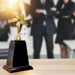 celebration of group successful businesspeople celebrate in success business holding golden award on soft blue background