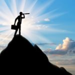 Silhouette of a businessman looking through a telescope